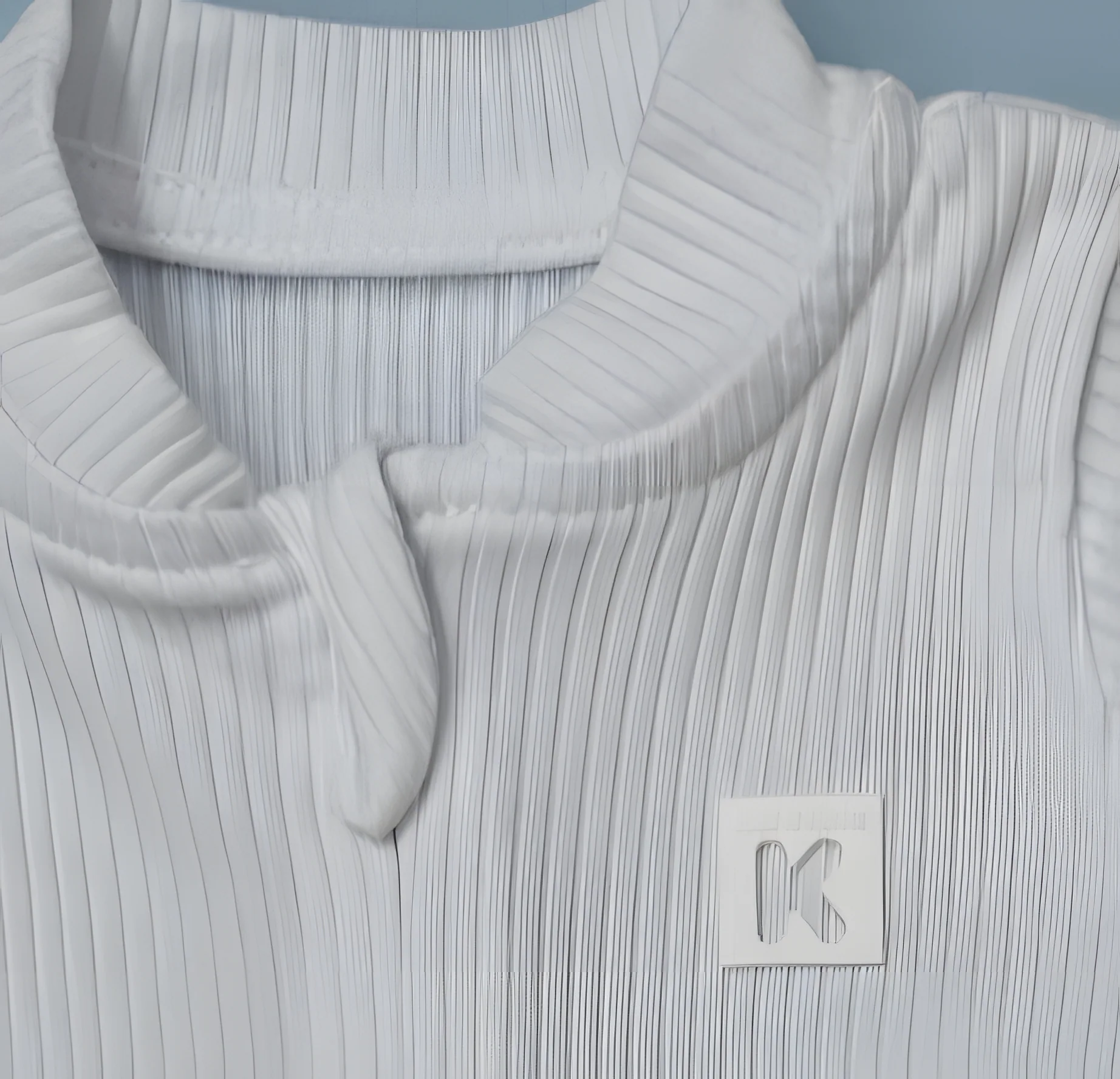 Gola canelada de um macacão branco, com a etiqueta K da Keru Kolu em relevo