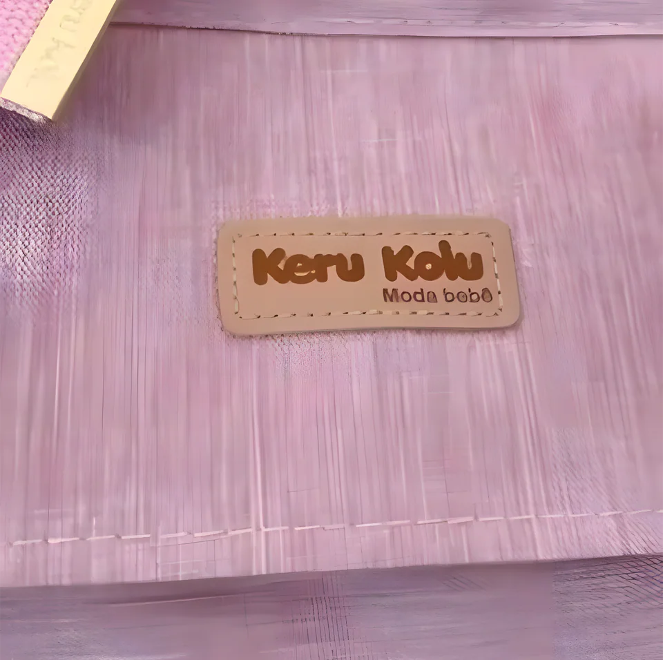 Bolsa rosa com a etiqueta Keru Kolu Moda Bebê costurada na frente